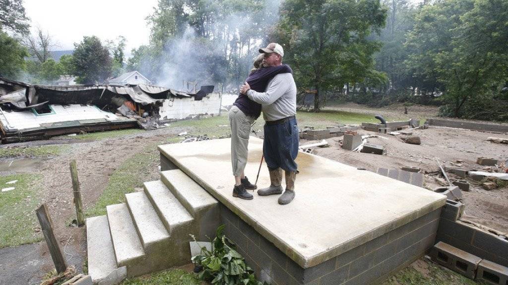 Ein Paar umarmt sich auf den Resten seines Hauses in White Sulphur Springs im US-Bundesstaat West Virginia.