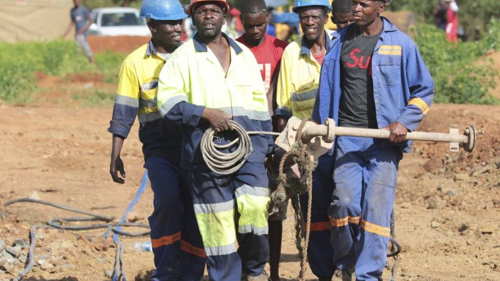 Minenarbeiter mit schwerem Gerät auf dem Weg zur überfluteten Goldmine in Simbabwe, in der dutzende illegal tätige Goldschürfer ums Leben gekommen sein dürften.