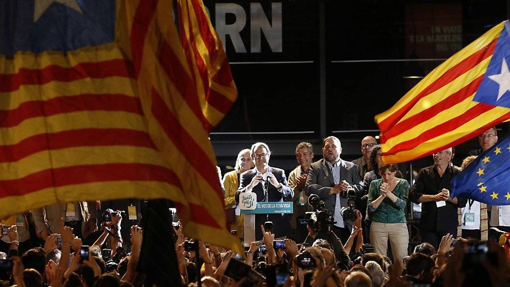 Regierungschef Artur Mas tritt vor Anhängerinnen und Anhänger und verkündet den Sieg seiner Wahlallianz. Tausende Menschen gingen am Sonntagabend in Barcelona auf die Strasse, um zu feiern.