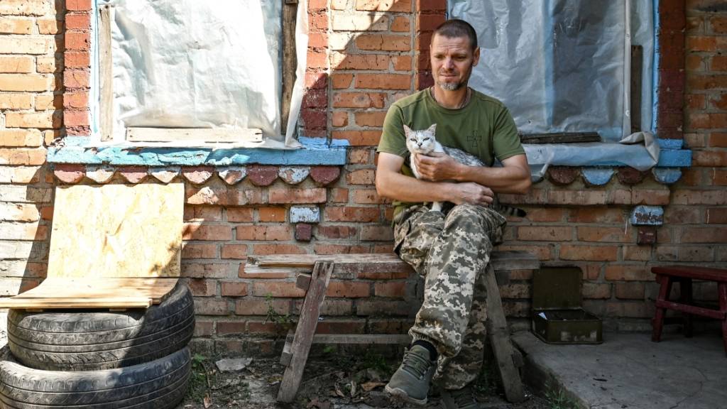 Ein Soldat der Territorialen Verteidigung aus Dnipro legt eine Pause ein - eine Katze leistet ihm Gesellschaft. Foto: ---/Ukrinform/dpa