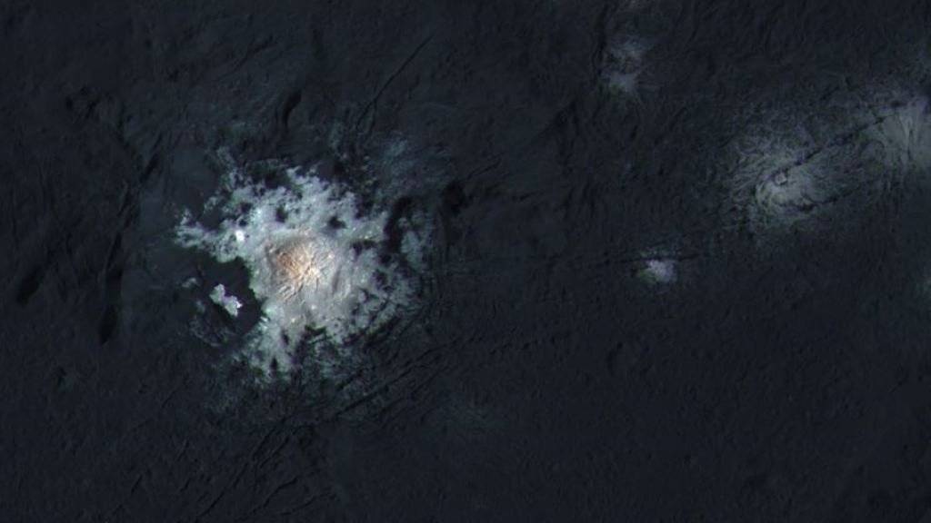 Kontrastverstärktes Bild des hellen Flecks im Occator Krater auf Zwergplanet Ceres. Eine hochauflösende Aufnahme vom Februar 2016 wurde hierfür mit Farbbildern kombiniert, welche die Raumsonde Dawn bereits im September aufgenommen hatte.