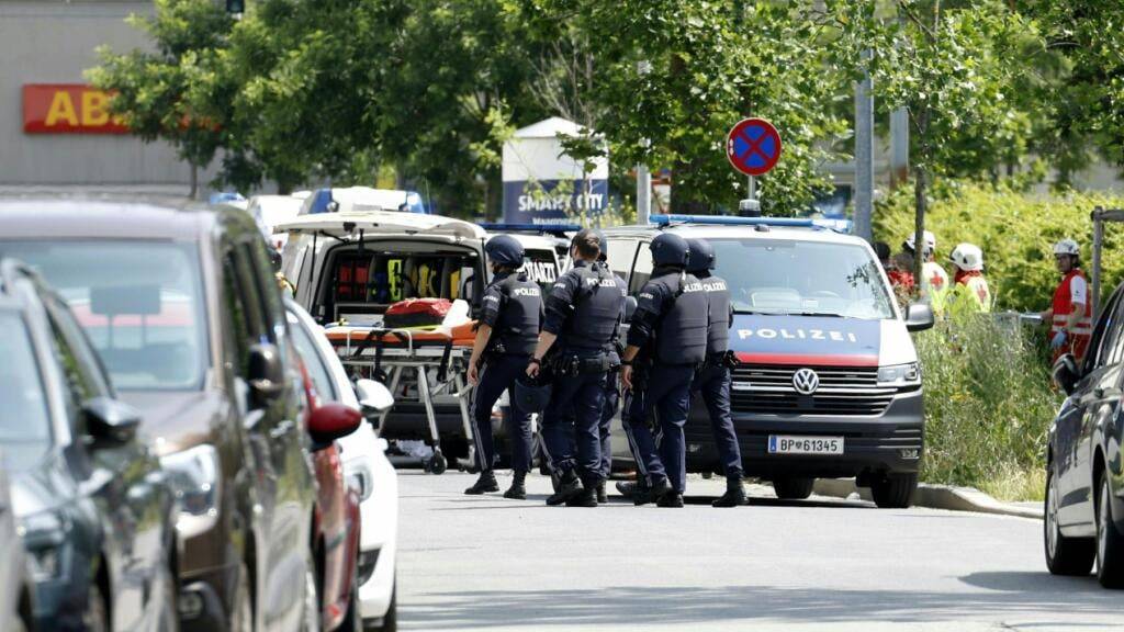 Einsatzkräfte stehen in der Nähe des Tatorts. Ein Polizei-Großeinsatz ist in einer Grazer Schule in der Dreierschützengasse angelaufen.  Bei den Schüssen an einer Grazer Schule sind nach Angaben des ORF mehrere Menschen getötet worden.. Foto: Erwin Scheriau/APA/dpa