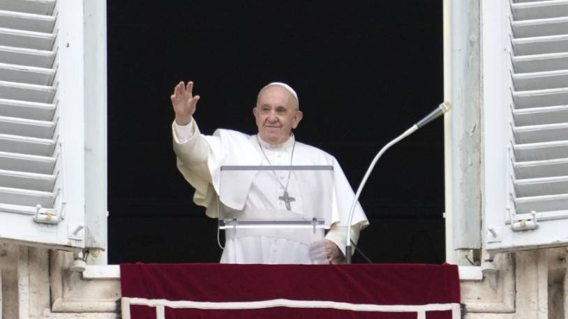 Papst Franziskus winkt aus seinem Fenster, während er das Angelus-Gebet auf dem Petersplatz spricht. Foto: Gregorio Borgia/AP/dpa