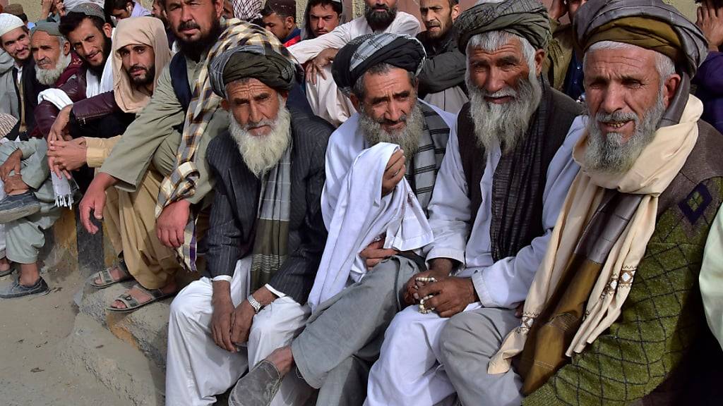 dpatopbilder - Afghanische Einwanderer warten vor dem afghanischen Konsulat darauf, dass sie ein Reisedokument für die Rückkehr in ihr Heimatland erhalten. Foto: Arshad Butt/AP/dpa