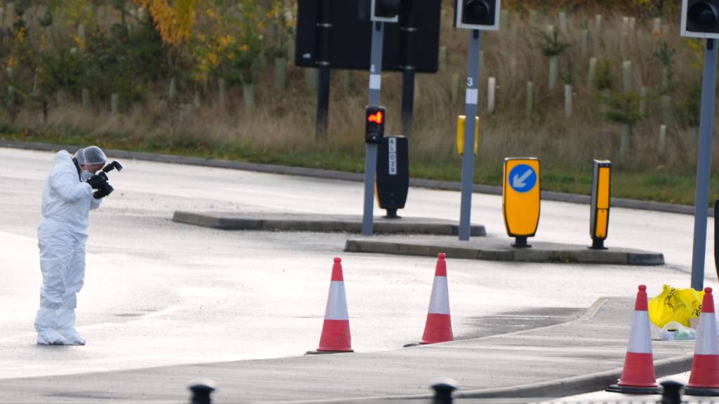 Ein Gerichtsmediziner macht Fotos von der Straße, die zum Bahnhof führt. Foto: Kirsty Wigglesworth/AP/dpa