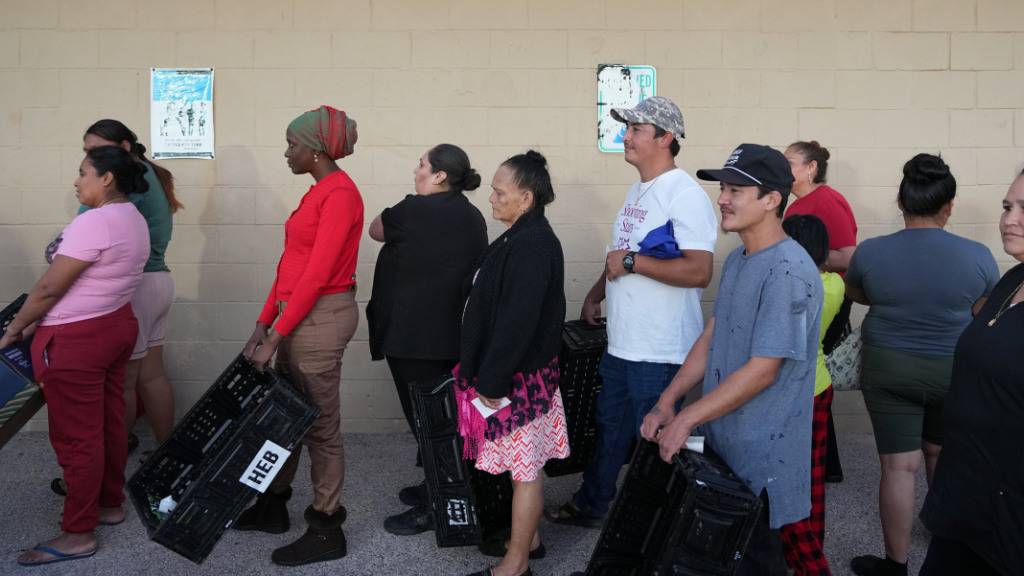 ARCHIV - Menschen warten in einer Schlange vor einer Verteilerstelle der Central Texas Food Bank. Foto: Jay Janner/Austin American-Statesman/dpa - ACHTUNG: Nur zur redaktionellen Verwendung und nur mit vollständiger Nennung des vorstehenden Credits
