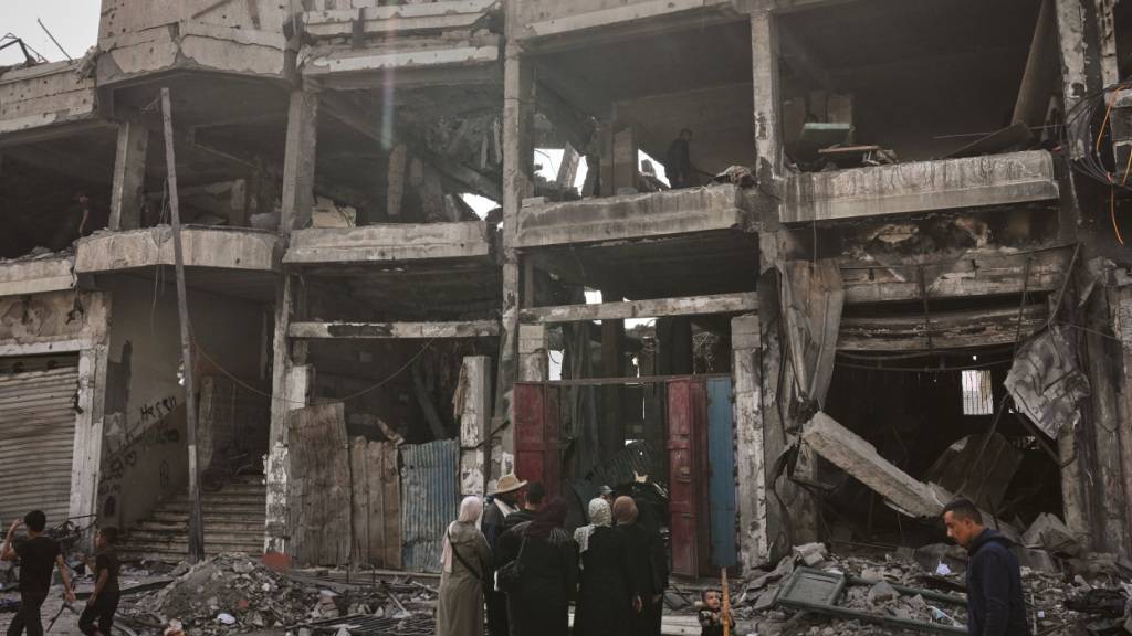 ARCHIV - Palästinenser inspizieren einen Tag nach einem israelischen Angriff auf ein Gebäude in Gaza die Ruinen. Foto: Jehad Alshrafi/AP/dpa/Archiv