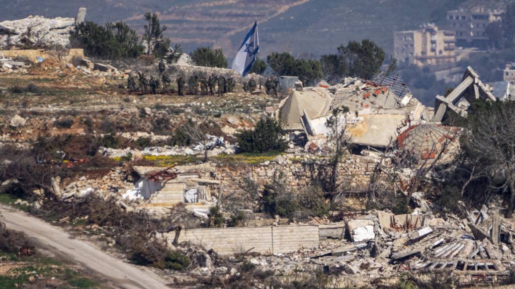 ARCHIV - Israelische Soldaten stehen neben einer israelischen Flagge in einem Dorf im Südlibanon, aufgenommen im Norden von Israel. Foto: Ariel Schalit/AP/dpa