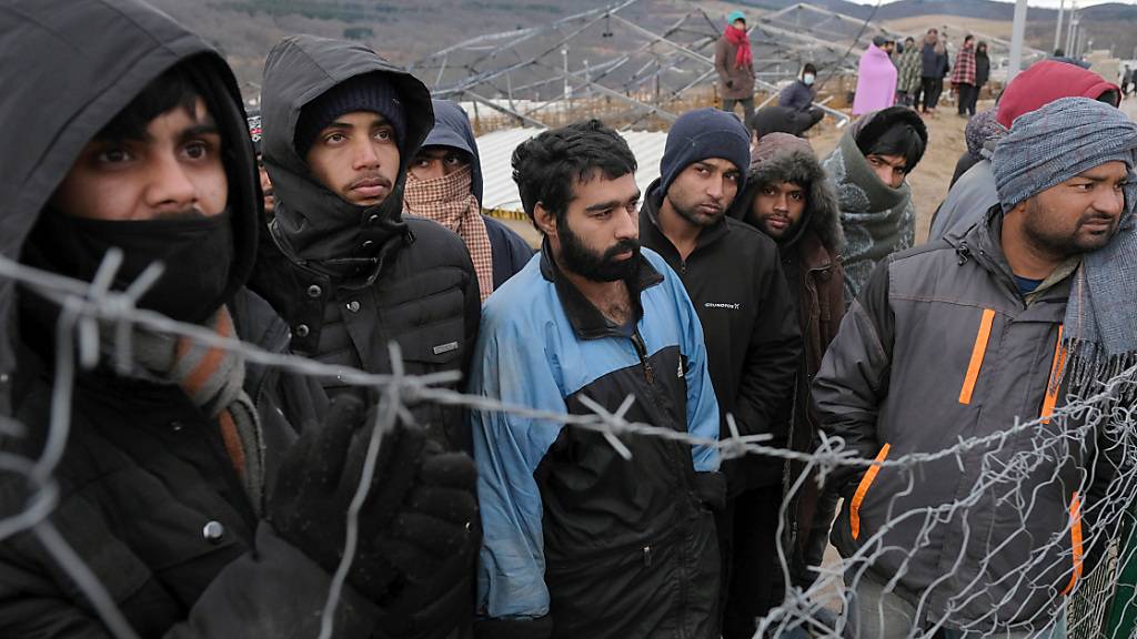 Migranten beobachten bosnische Soldaten beim Aufbau der Zelte im Lager Lipa. Wegen der Not von Hunderten Migranten in Bosnien-Herzegowina hat Pro Asyl der Europäischen Union Totalversagen vorgeworfen. Foto: Kemal Softic/AP/dpa