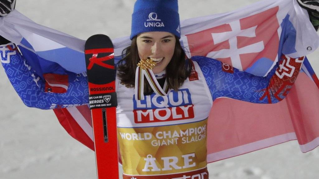 Petra Vlhova, das Gold zwischen den Zähnen, präsentiert sich stolz mit der slowakischen Flagge