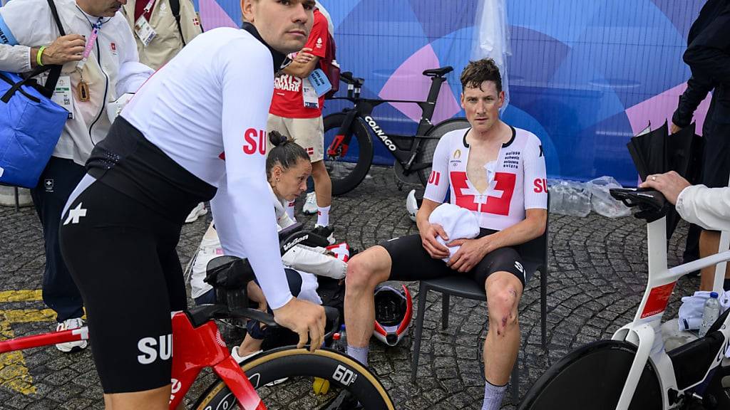 Stefan Küng (sitzend) und Stefan Bissegger (auf dem Velo) nach dem olympischen Zeitfahren in Paris