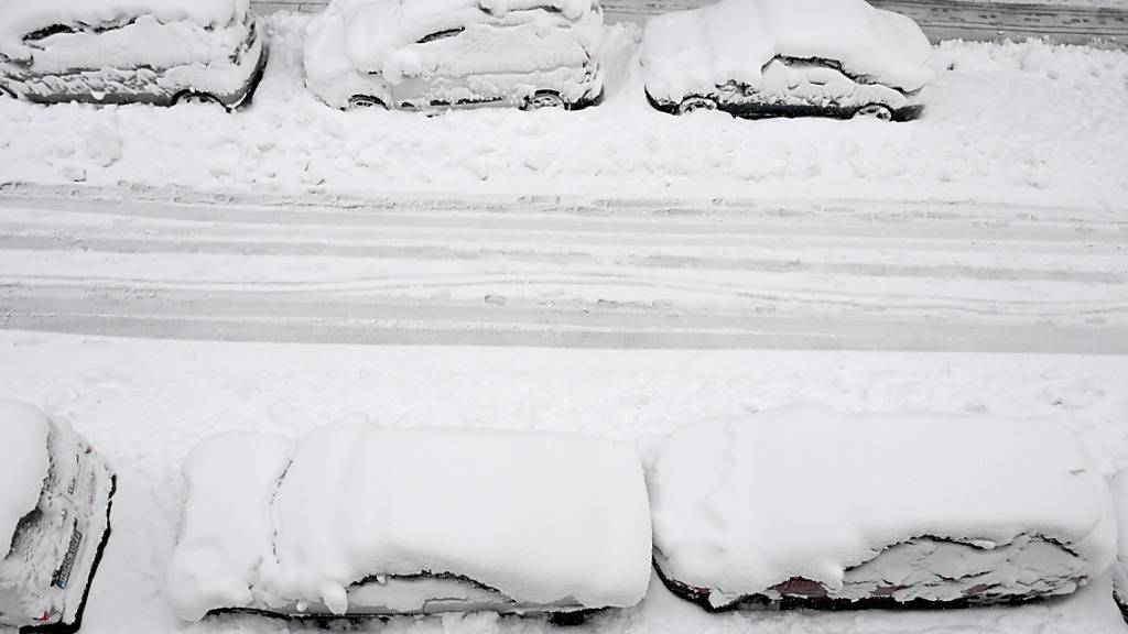 dpatopbilder - Hohe Schneemassen liegen auf Autos und einer Straße in der Landeshauptstadt. Schnee und Eis haben im Süden Bayerns auf den Straßen und bei der Bahn für Chaos gesorgt. Foto: Felix Hörhager/dpa