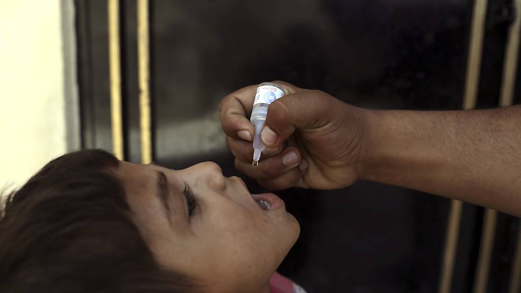 ARCHIV - Ein Mitarbeiter des Gesundheitswesens in Kabul verabreicht einem Kind eine Polio-Impfung. Foto: Rahmat Gul/AP/dpa