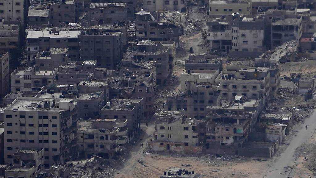 Zerstörte Gebäude im Gazastreifen sind durch das Fenster eines C-17-Flugzeugs der US-Luftwaffe zu sehen. Foto: Hussein Malla/AP/dpa