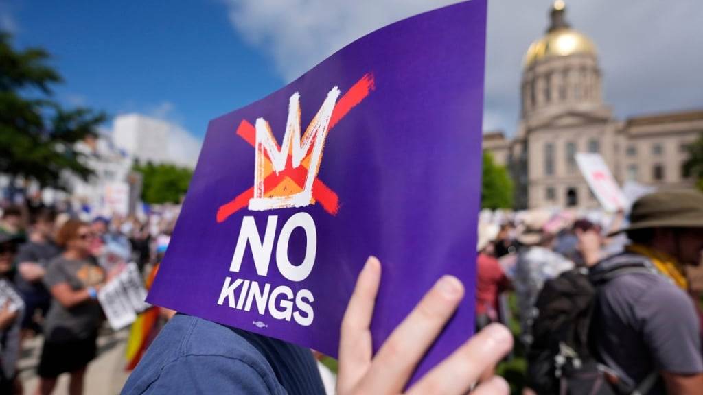 Ein Demonstrant hält ein Schild mit der Aufschrift «No Kings», während einer «No Kings»-Demonstration in Atlanta, Georgia. Foto: Mike Stewart/AP/dpa