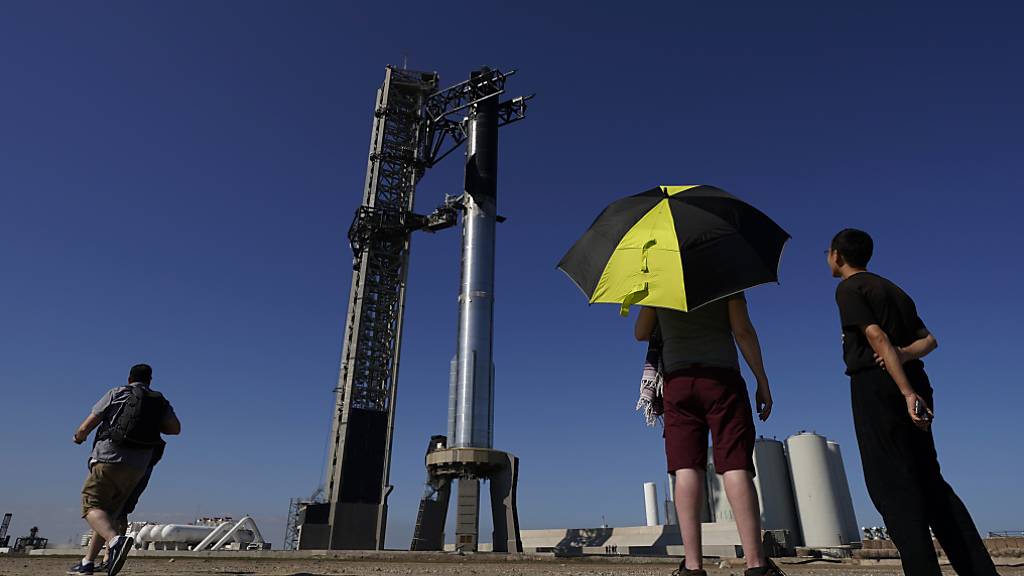 Schaulustige beobachten, wie die Rakete «Starship» von SpaceX für ihren bevorstehenden Start vorbereitet wird. Foto: Eric Gay/AP/dpa