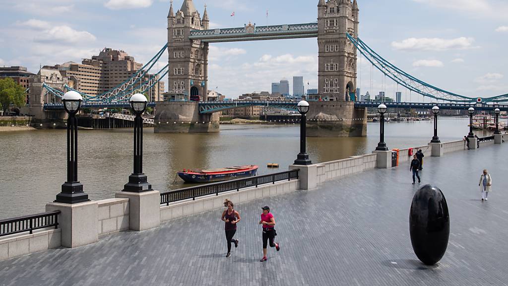 Jogger laufen in London am Ufer der Themse entlang. Foto: Dominic Lipinski/PA Wire/dpa