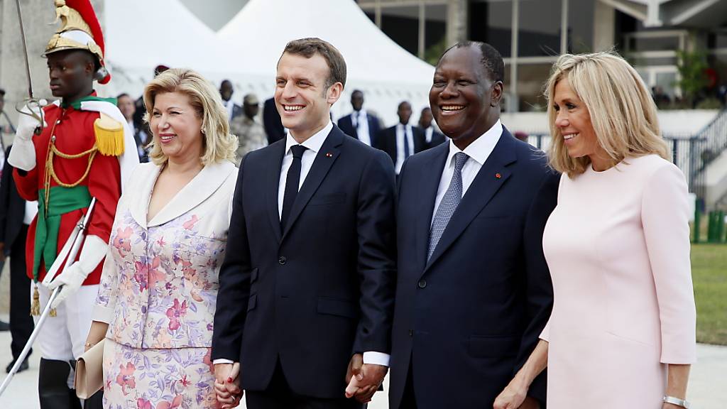 Der französische Präsident Emmanuel Macron (Mitte) mit seiner Gattin Brigitte (rechts) und seinem Amtskollegen aus der Elfenbeinküste, Alassane Ouattara, sowie dessen Gattin Dominique Folloroux-Ouattara in Abidjan.