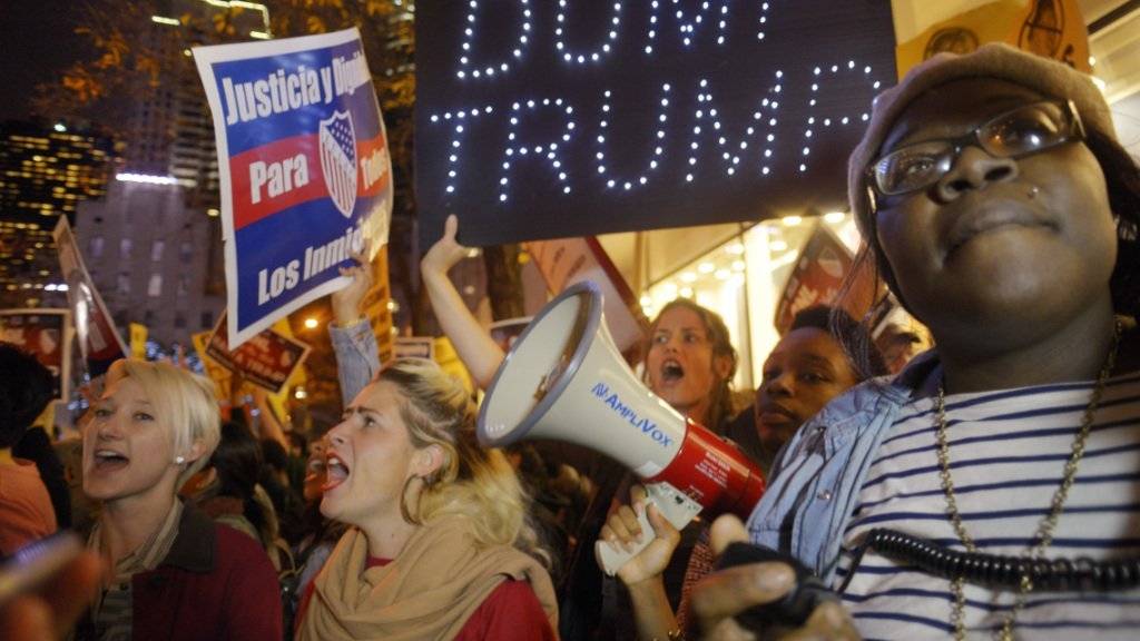Protest in New York gegen Trump und dessen Auftritt in der Sendung «Saturday Night Live». Auf dem Transparent steht auf deutsch übersetzt: «in den Müll mit Trump»