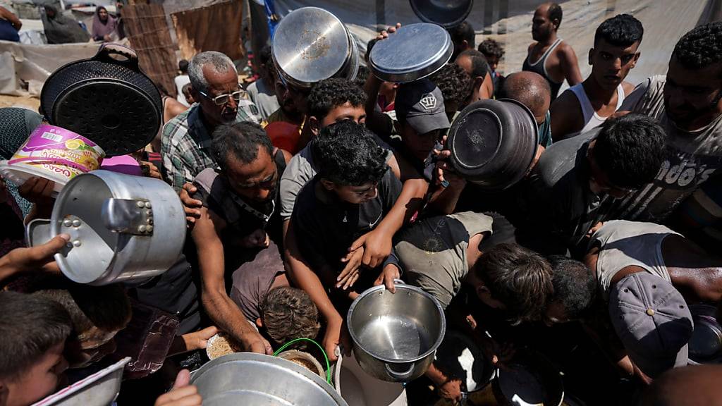 Vertriebene Palästinenser stehen in der Stadt Deir al-Balah im Gazastreifen für eine Lebensmittelverteilung an. (Archivbild)