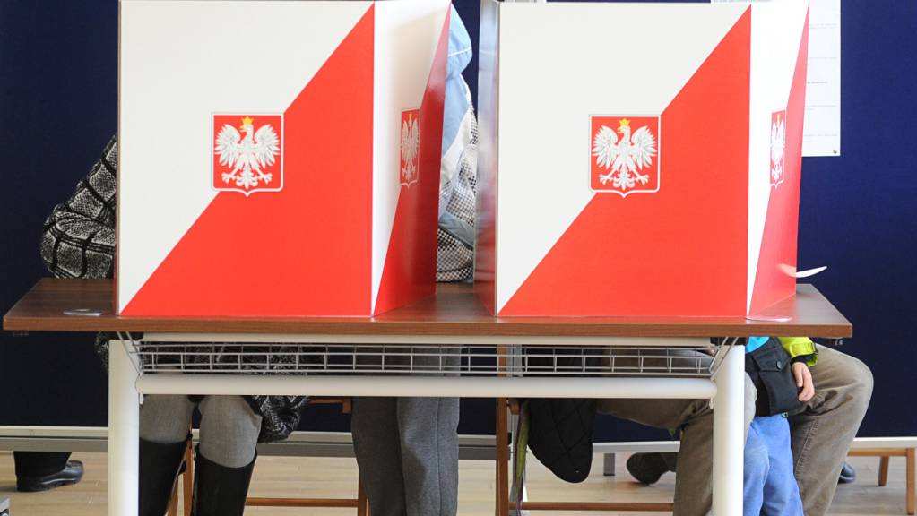 Wähler hinter Wahlurnen in der polnischen Hauptstadt Warschau. (Archivbild)