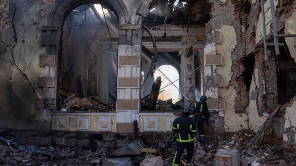 ARCHIV - Feuerwehrleute löschen das Feuer in einem Bahnhof nach einem russischen Angriff. Foto: Alex Babenko/AP/dpa