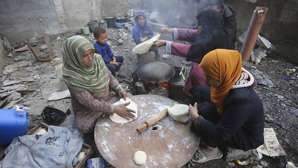 dpatopbilder - Frauen backen Brot neben ihren zerstörten Häusern im Dorf Khuza'a im südlichen Gazastreifen während des vorübergehenden Waffenstillstands zwischen der Hamas und Israel. Foto: Hatem Ali/AP