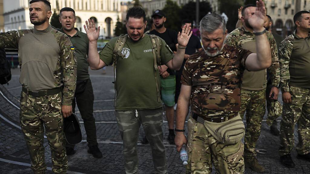Eine Gruppe ukrainischer Soldaten betet während eines von einer örtlichen christlichen Kirche organisierten Gottesdienstes. Foto: Jae C. Hong/AP/dpa