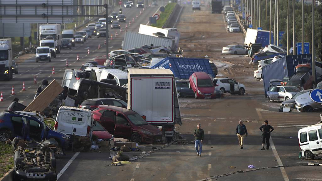 dpatopbilder - Auf einer Autobahn stapeln sich Fahrzeuge, die von den Fluten weggeschwemmt wurden. Foto: Manu Fernandez/AP