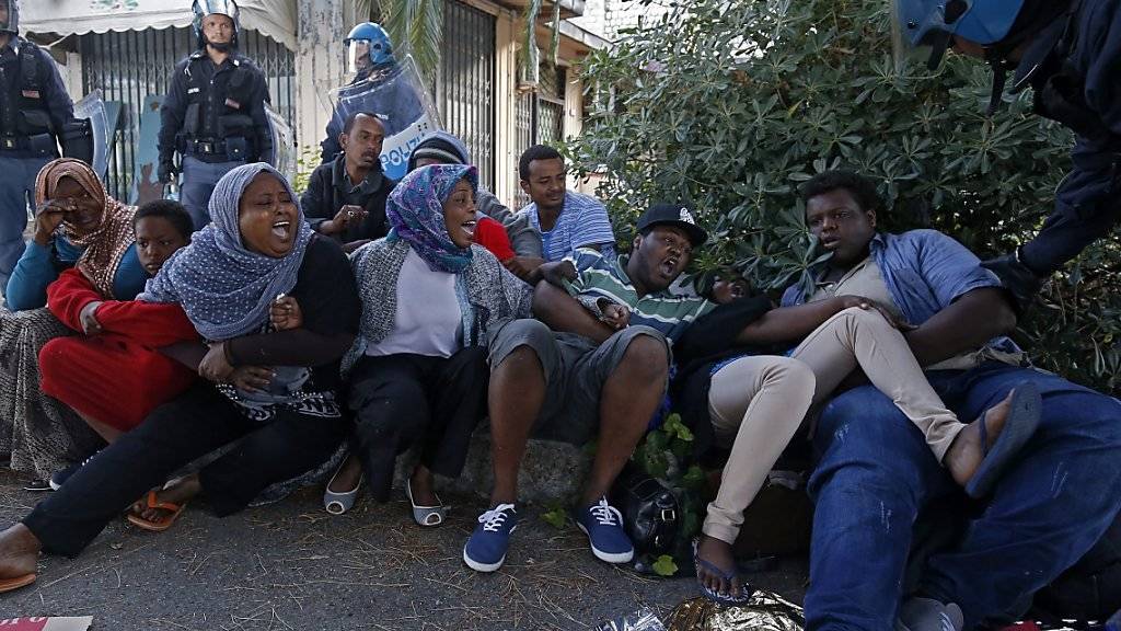 Die italienische Polizei versucht Flüchtlinge, die an der italienisch-französischen Grenze bei Ventimiglia blockiert sind, in ein Flüchtlingslager zu bringen. Die Afrikaner wollen - wie so viele andere - nach Frankreich. (Archiv)