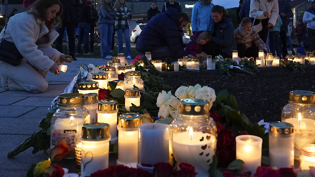 Personen zünden Kerzen an in Gedenken an die Opfer. Nach der Gewalttat mit fünf Toten in der norwegischen Kleinstadt Kongsberg kann die Polizei einen terroristischen Hintergrund nicht ausschließen. Die Zurechnungsfähigkeit des Tatverdächtigen wird von Psychiatern überprüft. Foto: Terje Bendiksby/NTB/dpa