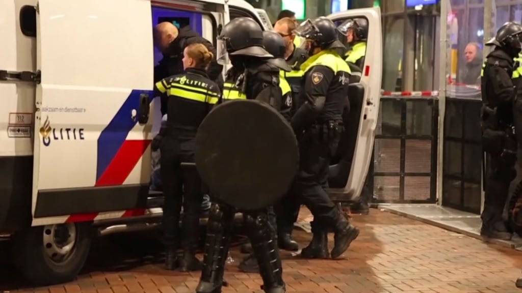 SCREENSHOT - Auf diesem Videostandbild nimmt die Polizei einen Mann in der Nähe des Ajax-Stadions fest, nachdem die Lage nach dem Fußballspiel eskalierte und es zu gewaltsamen Ausschreitungen in der Stadt kam. Foto: InterVision/AP/dpa