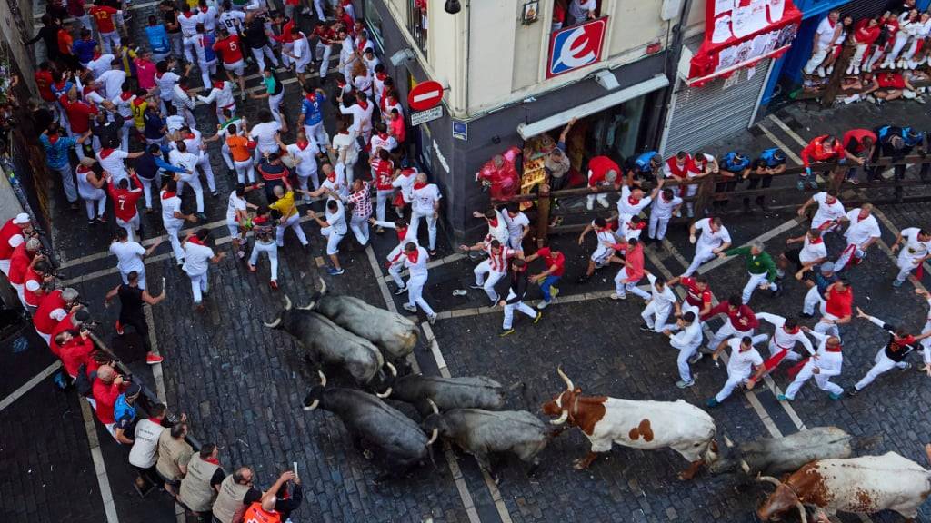 dpatopbilder - Teilnehmer treiben die Stiere von José Escolar Gil am sechsten Tages der San Fermin-Festlichkeiten durch die Innenstadt. Foto: Miguel Oses/AP/dpa