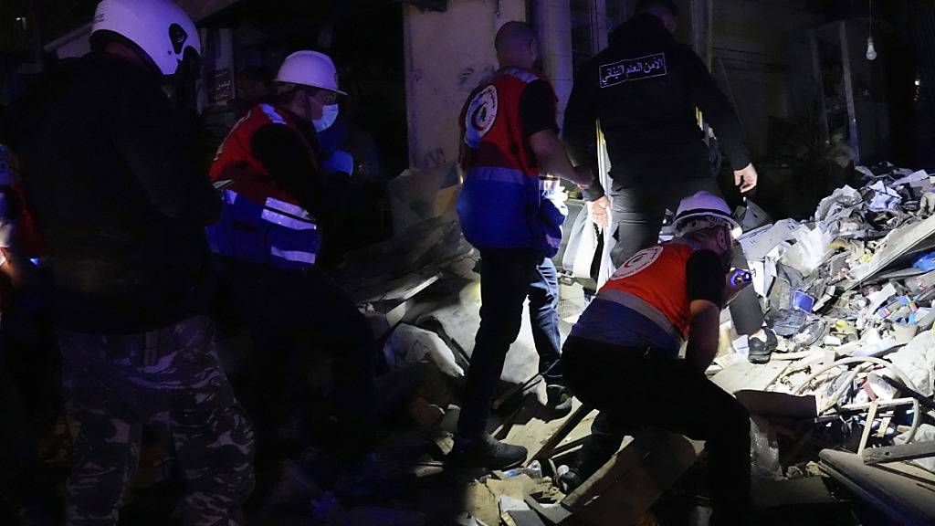 Rettungskräfte und Polizisten suchen nach Opfern eines israelischen Luftangriffs. Foto: Hussein Malla/AP/dpa