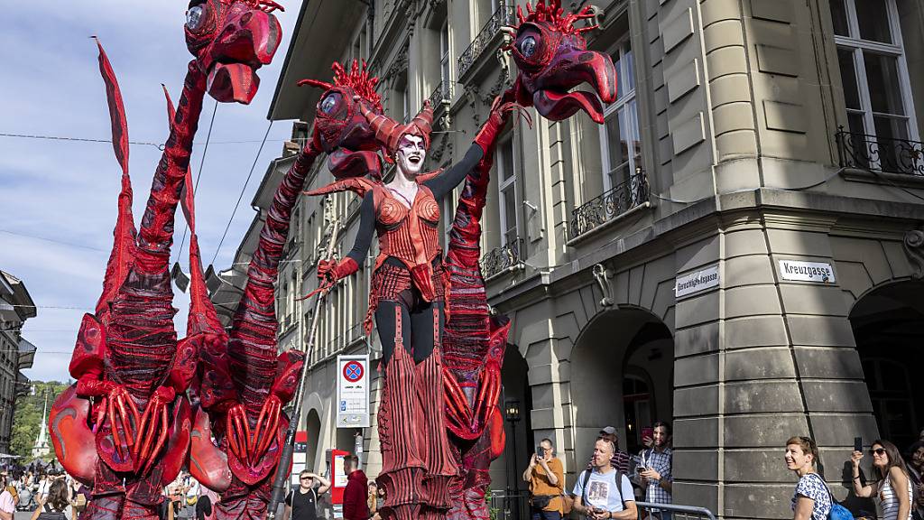 Dinosaurier strömen durch die Gassen an der Eröffnung des 20. Buskers Festival in Bern.