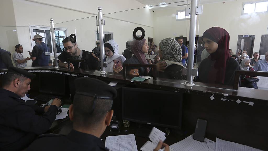 Palästinenser mit doppelter Staatsangehörigkeit lassen  sich am Donnerstag auf der Seite des Gazastreifens am Grenzübergang in Rafah für die Ausreise nach Ägypten registrieren. Foto: Hatem Ali/AP