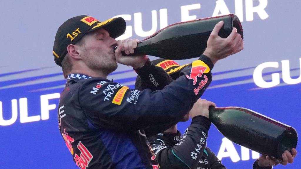 Max Verstappen geniesst nach seinem 72. GP-Sieg, dem ersten seit Dezember 2025, den Schluck aus der Champagner-Flasche