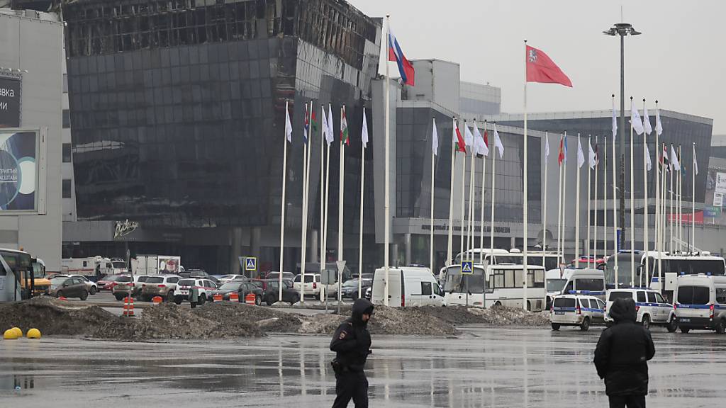 Polizisten sichern einen Bereich in der Nähe des Krokus-Rathauses. Nach dem Terroranschlag im Nordwesten Moskaus auf eine Konzerthalle dauern die Ermittlungen an. Die Behörden geben Informationen zu Verletzten und Toten - und rufen die Menschen zu Blutspenden auf. Foto: Vitaly Smolnikov/AP/dpa