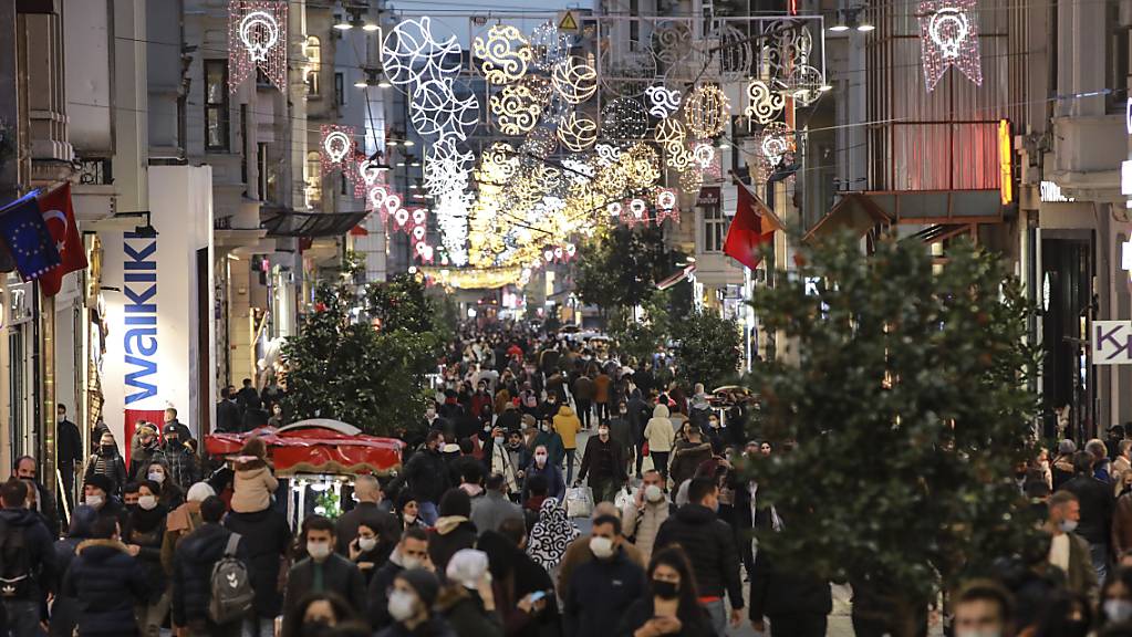 Menschen spazieren wenige Stunden vor der Sperrstunde entlang der Haupteinkaufsstrasse in Istanbul. Die türkische Regierung hat entgegen der bisherigen Praxis die täglichen Fallzahlen der positiv auf das Coronavirus getesteten Menschen im Land bekanntgegeben. Foto: Emrah Gurel/AP/dpa