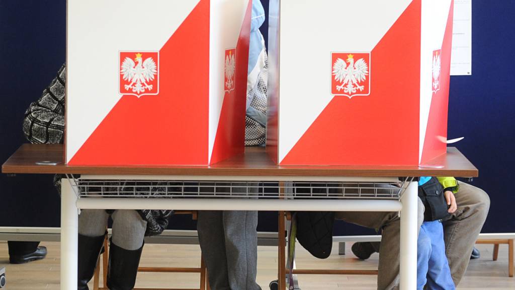 Wähler hinter Wahlurnen in der polnischen Hauptstadt Warschau. (Archivbild)