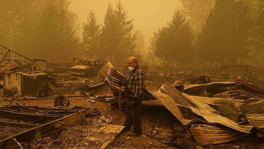 George Coble geht durch die Überreste seines Hauses im Bundesstaat Oregon, das durch einen Waldbrand zerstört wurde. Foto: John Locher/AP/dpa