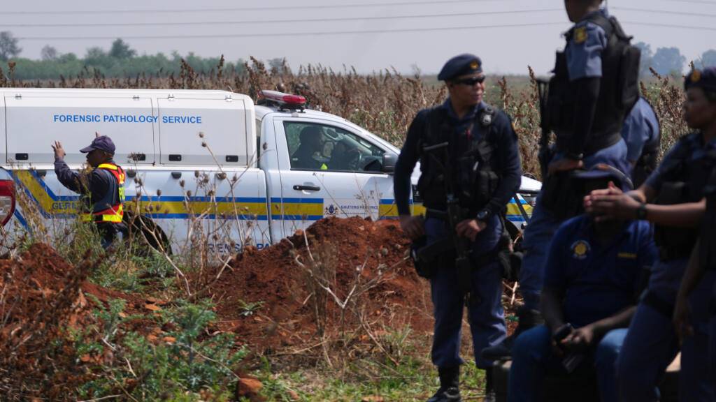 Kriminaltechniker sind an dem Ort im Einsatz, an dem am Stadtrand von Johannesburg die Leiche einer Frau entdeckt wurde. Foto: Themba Hadebe/AP/dpa