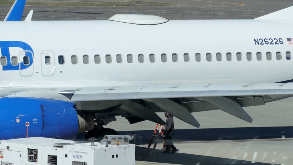 Ein Mitarbeiter des Medford Jet Centers geht unter einer Boeing 737-824 von United Airlines, die auf dem Rogue Valley International-Medford Airport aus San Francisco gelandet ist. Eine Passagiermaschine von United Airlines hat am Freitag im Flug eine Abdeckung an ihrem Rumpf verloren. Foto: Andy Atkinson/Rogue Valley Times/AP/dpa - ACHTUNG: Nur zur redaktionellen Verwendung und nur mit vollständiger Nennung des vorstehenden Credits