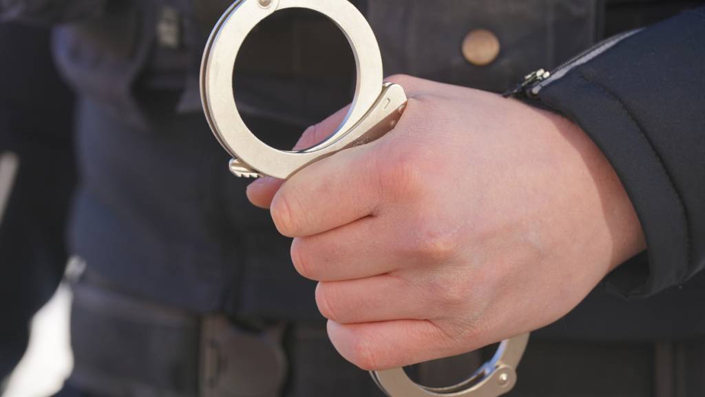 ARCHIV - Ein Polizist hält Handschellen in der Hand. Foto: Marcus Brandt/dpa