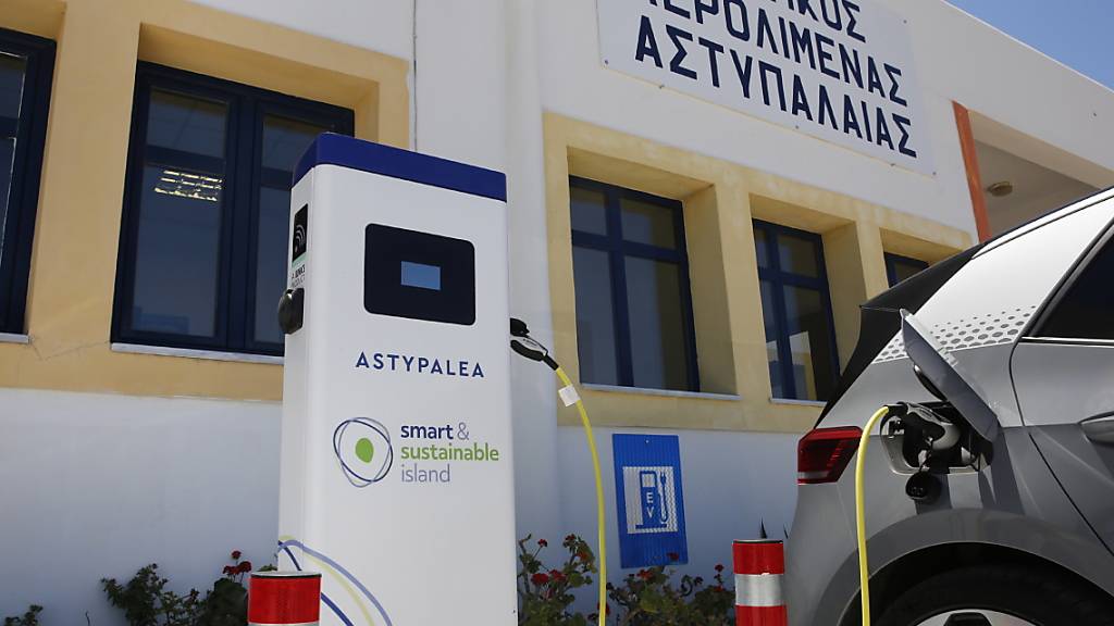Ein Elektroauto wird auf dem Parkplatz des Flughafens auf der griechischen Insel Astypalea aufgeladen. Seit dem 2. Juni sind die Bewohner der Insel vollkommen elektrisch unterwegs.