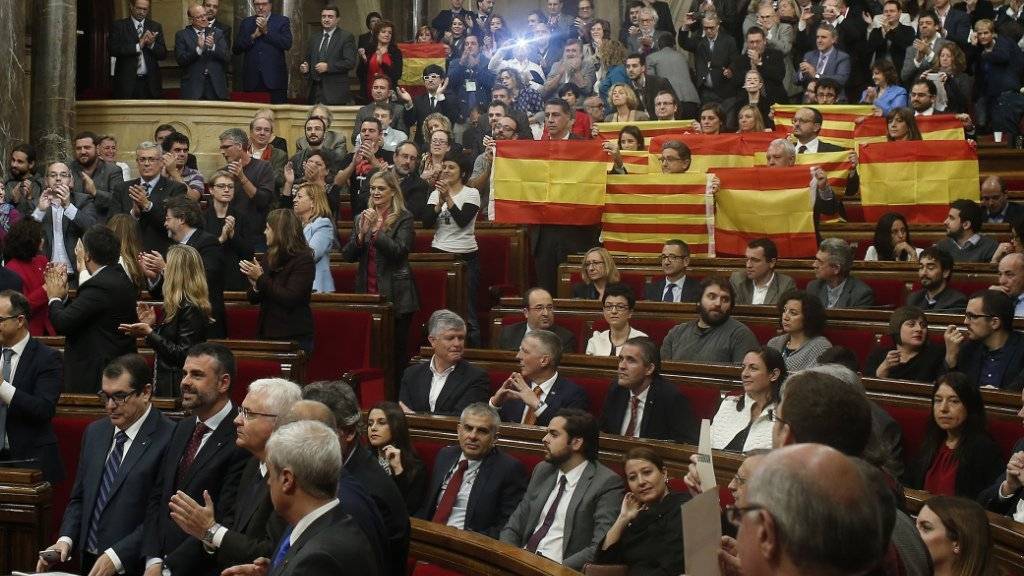 Mitglieder der Volkpartei PPC halten vor der Abstimmung im Parlament spanische und katalanische Flaggen in die Höhe - aus Protest gegen die bevorstehende Annahme der Abspalungsresolution.
