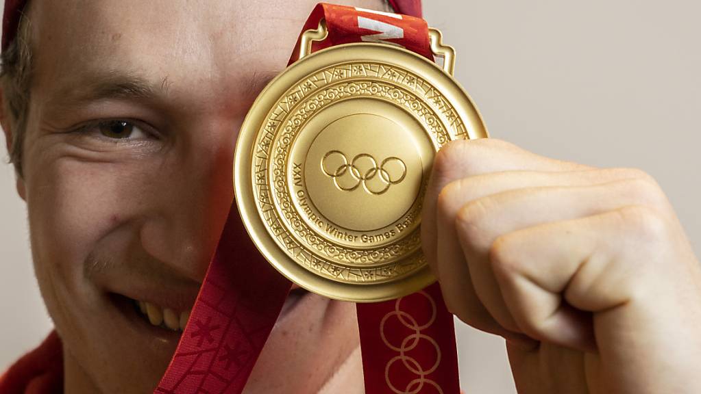Marco Odermatt zeigt seine Goldmedaille, eine von vier in China durch die Schweizer Alpinen gewonnenen