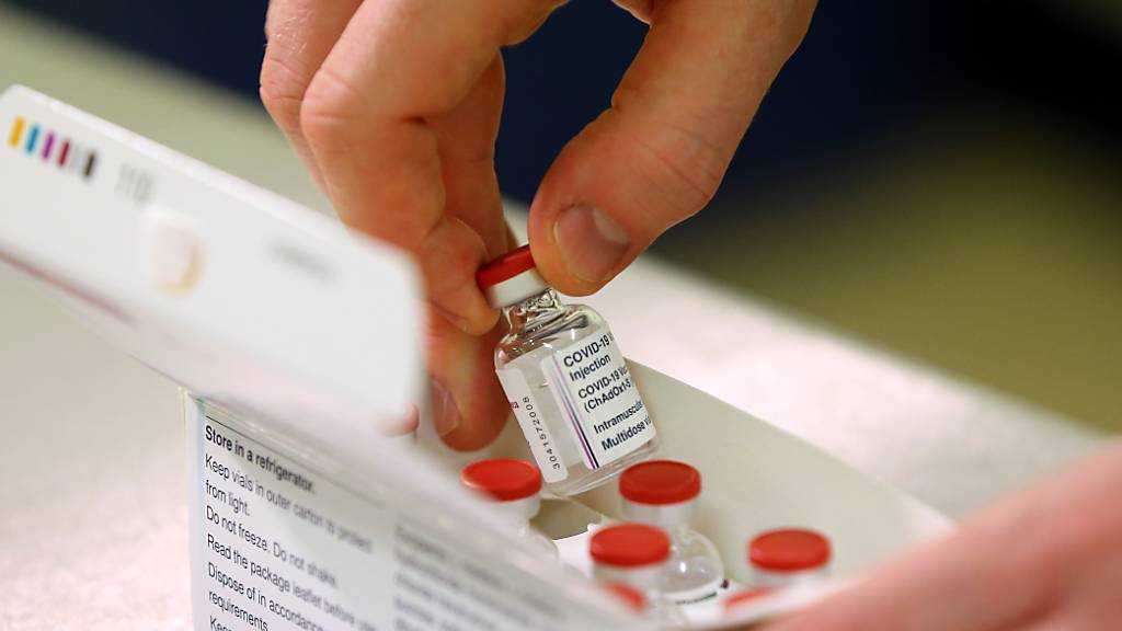 Ein Fläschchen des neu zugelassenen Impfstoffs gegen das Coronavirus der Universität Oxford und dem Pharmakonzern Astrazeneca wird aus einer Schachtel genommen, nachdem die erste Lieferung im Princess Royal Hospital eingetroffen ist. Foto: Gareth Fuller/PA Wire/dpa