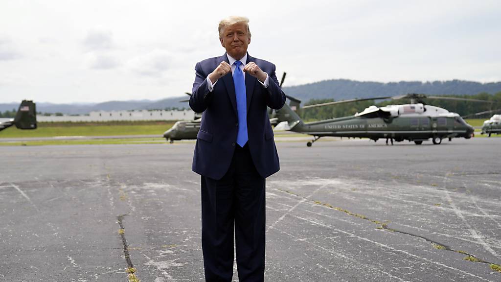 Donald Trump (l), Präsident der USA, gestikuliert nach seiner Ankunft am Flughafen Asheville. Foto: Evan Vucci/AP/dpa