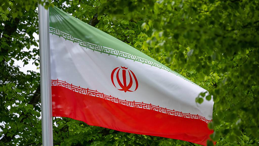 ARCHIV - Die Flagge der Islamischen Republik Iran weht im Wind vor der Botschaft des Staates an der Podbielskiallee. Ein im Iran seit September 2022 festgehaltener Franzose ist wieder frei. Foto: Monika Skolimowska/dpa